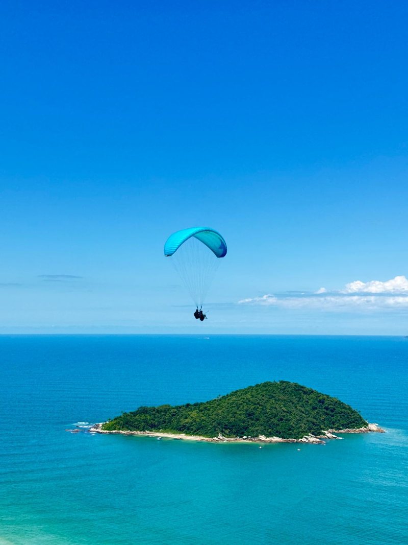Voo duplo sobre o mar da Praia de Palmas, com a ilha ao fundo